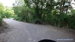 A young girl has her first ride on a motorbike with a stranger in the jungle