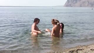 Three nudist girls on public beach with no clothes