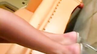 A woman in a leather suit masturbates herself on the chair