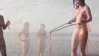 Nudist beauties have fun on the sandy beach