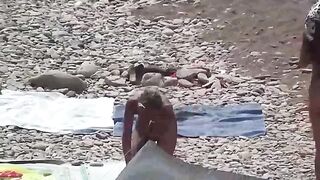 A couple of free-spirited lovers enjoy each other on the naked beach
