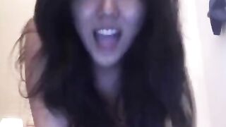 An Asian girl masturbating herself on webcam, showcasing her solo session on the bed