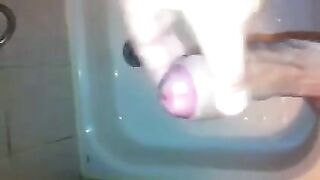 The kid caresses his dick under the stream of water in the shower