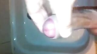 The kid caresses his dick under the stream of water in the shower