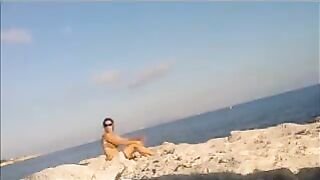 A hot young girl is basking in the sun naked on the beach