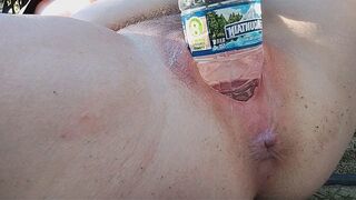 A girl reaches the peak of pleasure while playing with a water bottle